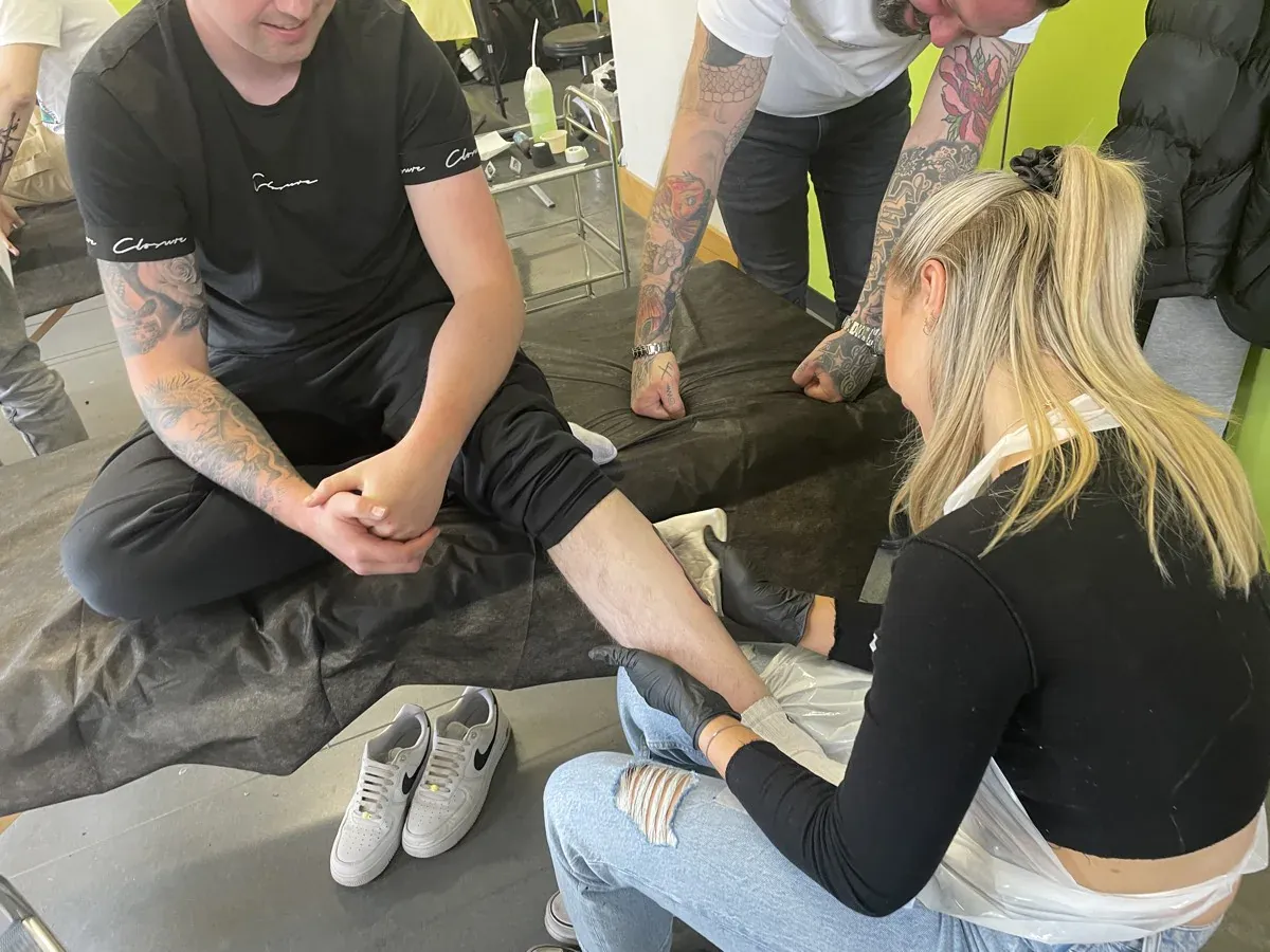 Tattoo students and tutor at work