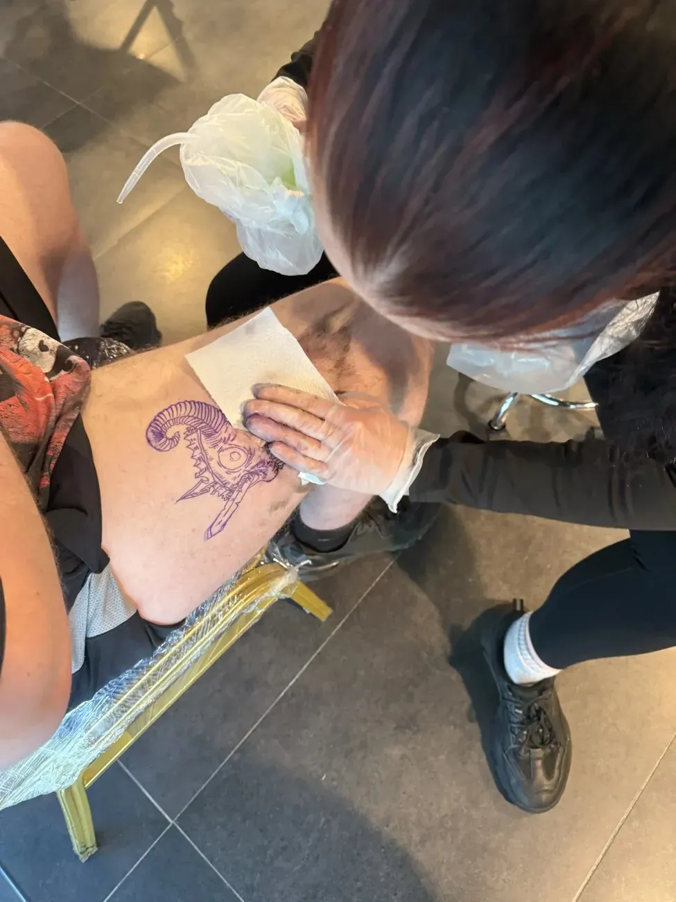 A tutor guiding a student in the Leeds Tattoo College studio